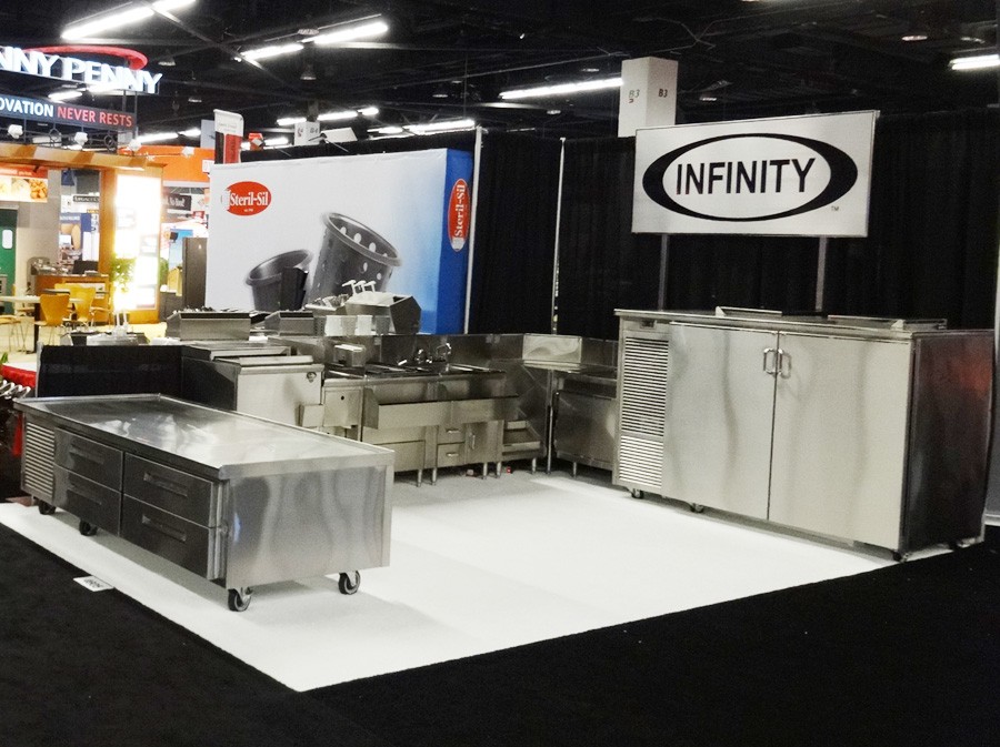 image of infinity trade show booth with low height with drawers refrigerator, bottle cooler, two compartment sink and backbar with doors from right side of booth
