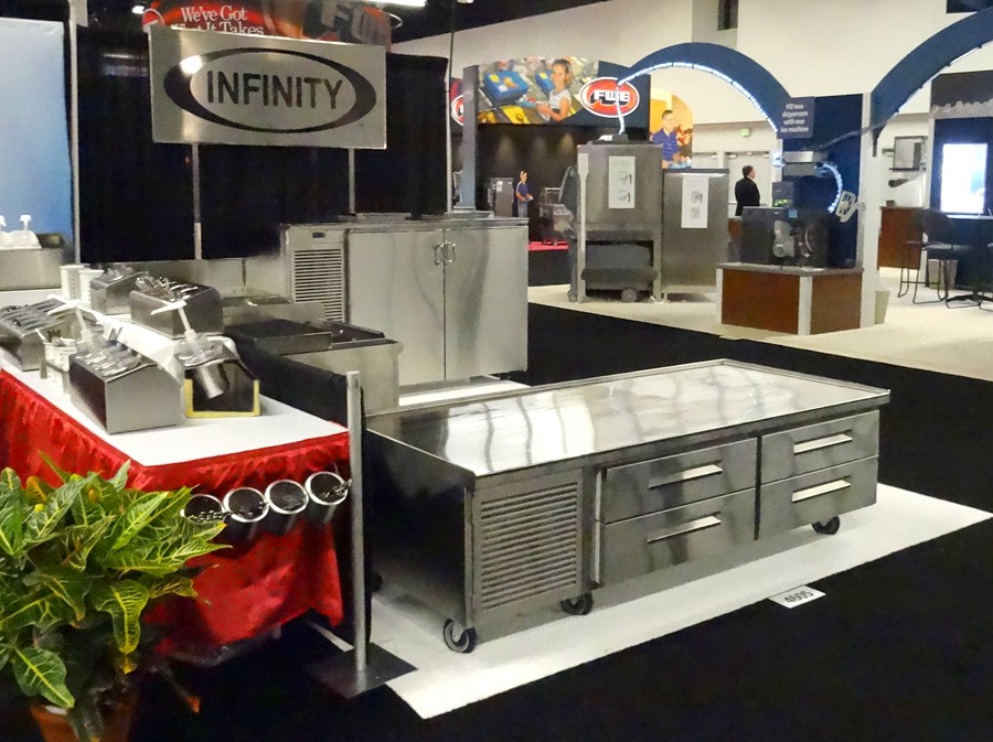 image of infinity trade show booth with low height with drawers refrigerator, bottle cooler, two compartment sink and backbar with doors from front of booth
